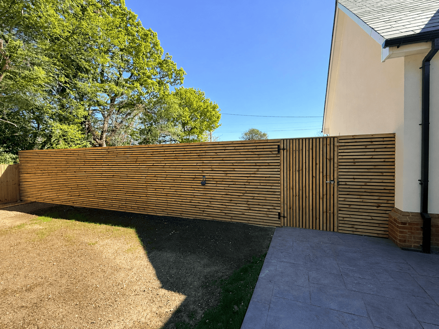 Contemporary slatted timber wall and matching gates built by TimBear Builds in Chelmsford
